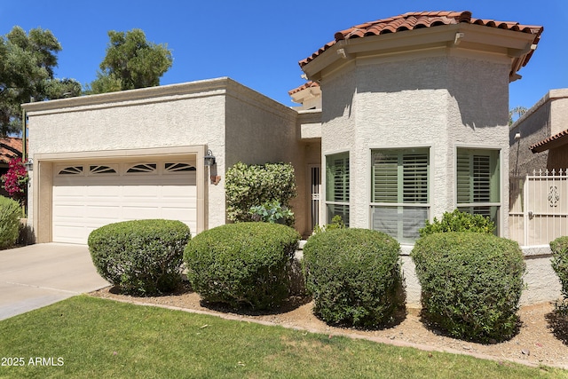 view of front of house featuring stucco siding, a tile roof, concrete driveway, and an attached garage