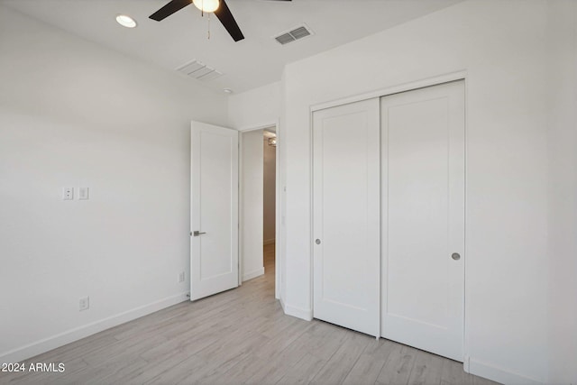 unfurnished bedroom featuring visible vents, ceiling fan, baseboards, light wood-style floors, and a closet