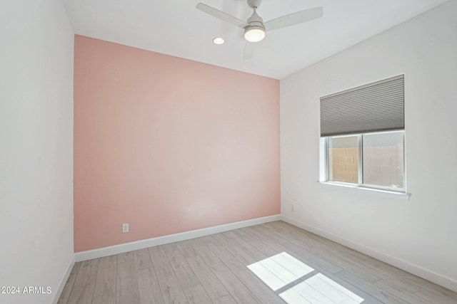 empty room with baseboards, a ceiling fan, and light wood finished floors