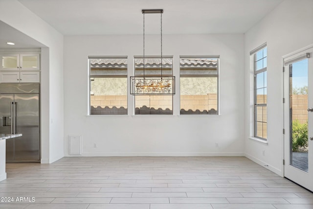 unfurnished dining area with baseboards and light wood-style floors