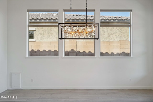 empty room with wood finished floors, baseboards, and a healthy amount of sunlight