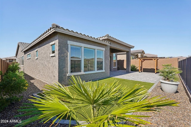 back of house featuring a patio area, stucco siding, a tiled roof, and a fenced backyard