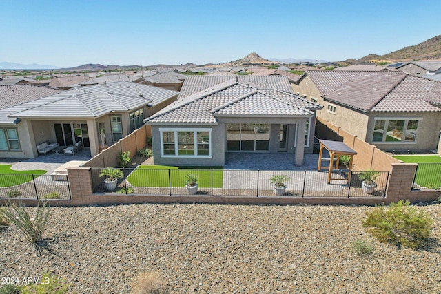 back of property featuring a patio, a yard, a fenced backyard, and a tile roof