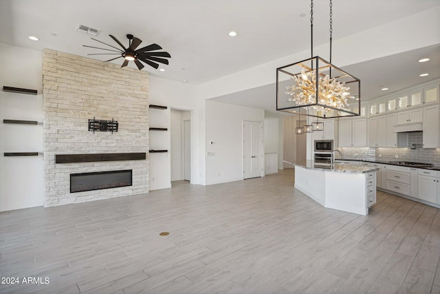 kitchen featuring tasteful backsplash, visible vents, open floor plan, appliances with stainless steel finishes, and light wood-style floors