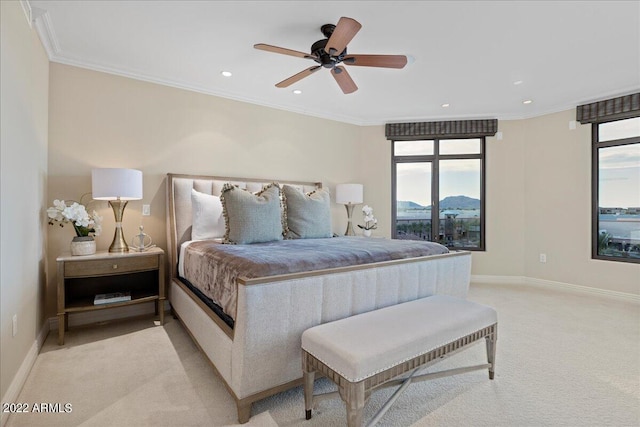 bedroom featuring a mountain view, light carpet, multiple windows, and ornamental molding