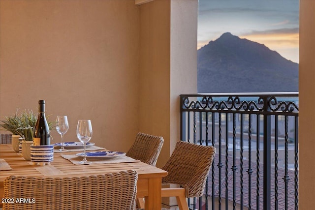 balcony at dusk featuring a mountain view