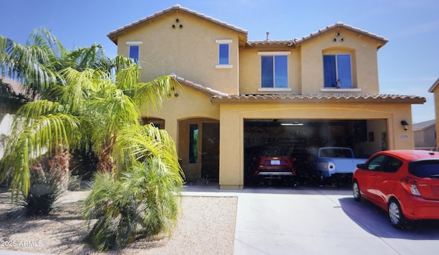 1309 W Park St, Phoenix, AZ 85041 - mediterranean / spanish-style house featuring driveway, a tiled roof, stucco siding, and an attached garage