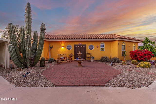 mediterranean / spanish-style house with a tile roof and stucco siding