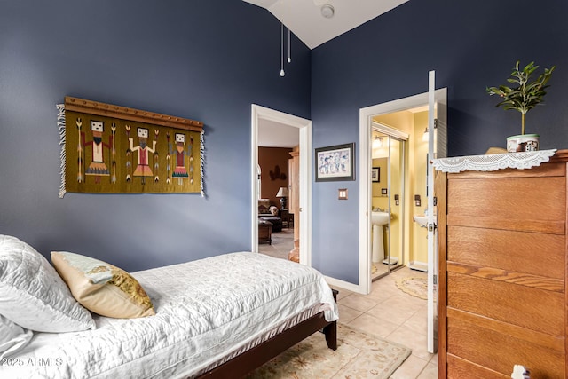tiled bedroom featuring baseboards, a sink, ensuite bath, and high vaulted ceiling