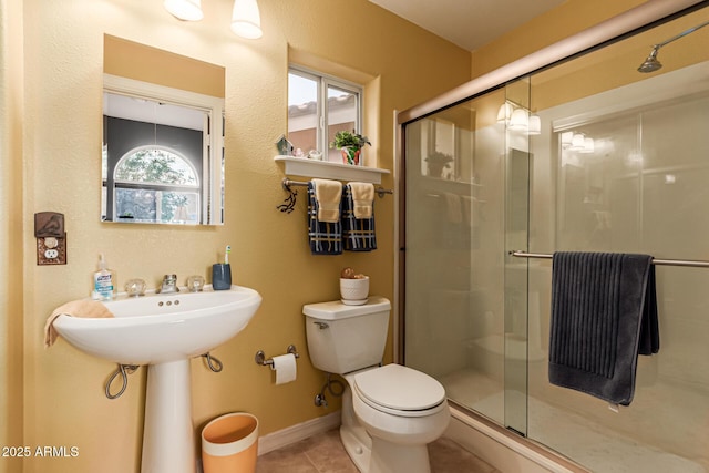 full bath with toilet, tile patterned floors, and a shower stall