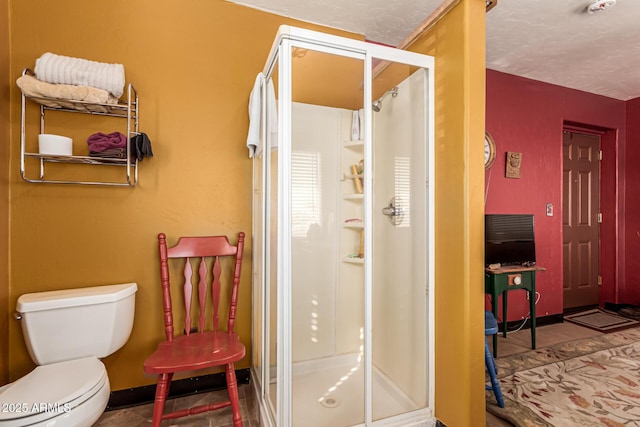 bathroom featuring a stall shower and toilet