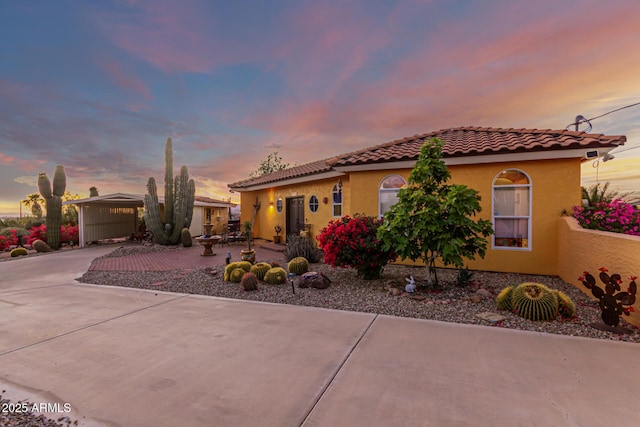 mediterranean / spanish house featuring concrete driveway, a tile roof, and stucco siding