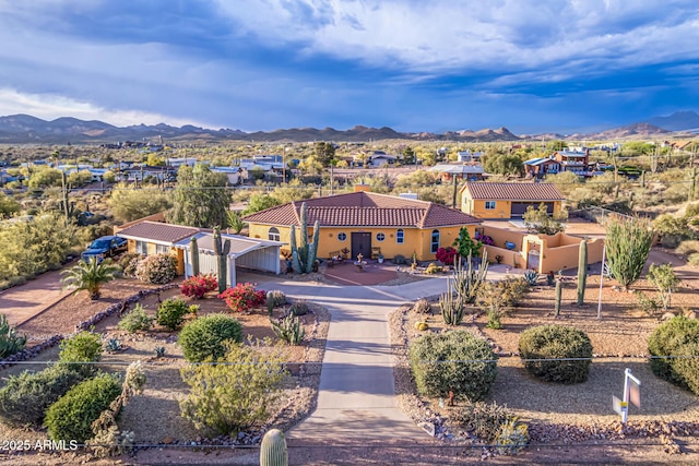 view of front of property with a mountain view, stucco siding, driveway, and a tile roof