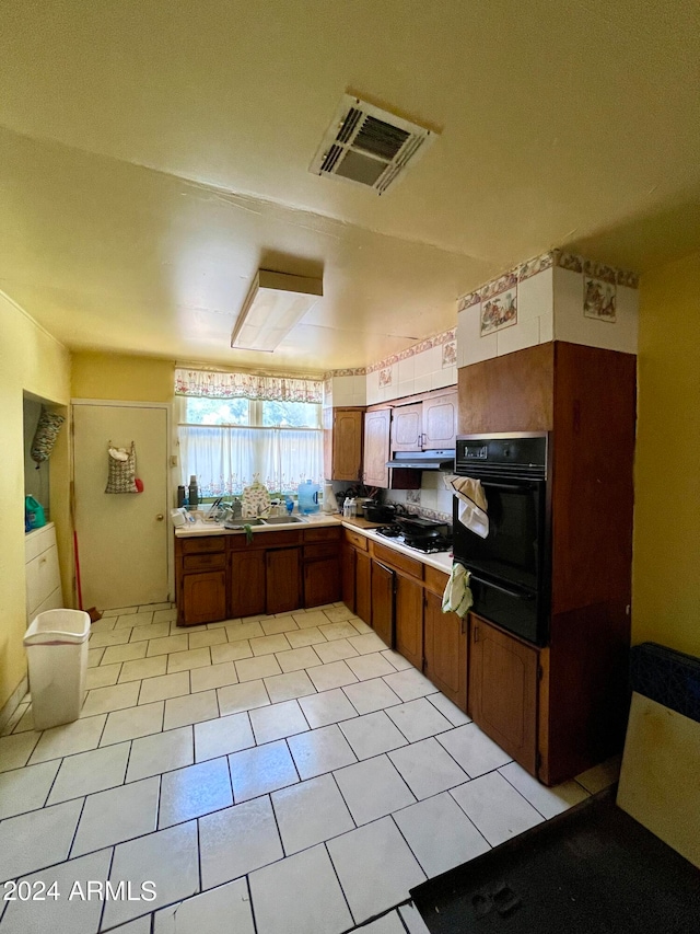 kitchen featuring light tile patterned floors, oven, and gas cooktop