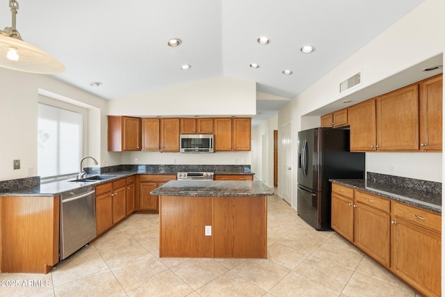 kitchen with visible vents, a kitchen island, dark stone countertops, stainless steel appliances, and a sink