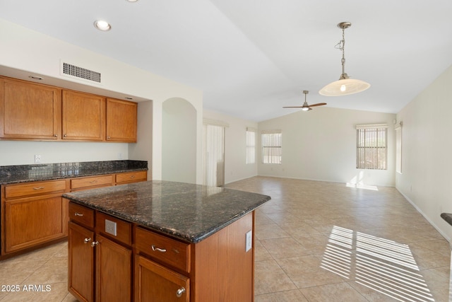 kitchen featuring vaulted ceiling, plenty of natural light, visible vents, and a center island