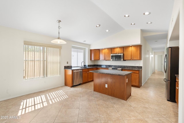 kitchen with dark countertops, a kitchen island, lofted ceiling, brown cabinetry, and stainless steel appliances