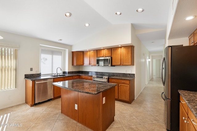 kitchen featuring brown cabinetry, a center island, stainless steel appliances, and a sink