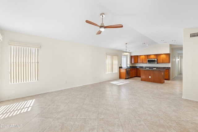 unfurnished living room with lofted ceiling, light tile patterned flooring, baseboards, and ceiling fan