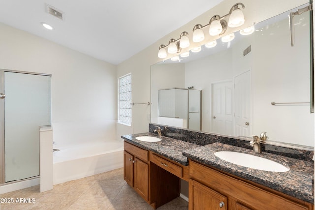 bathroom featuring visible vents, a stall shower, a garden tub, and a sink