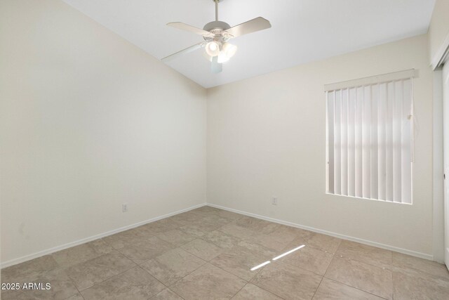 spare room with ceiling fan and baseboards