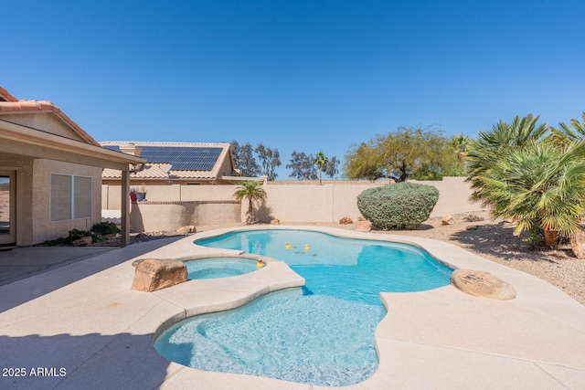 view of swimming pool featuring a patio, a pool with connected hot tub, and a fenced backyard