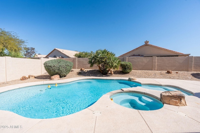 view of swimming pool featuring a fenced backyard and a pool with connected hot tub