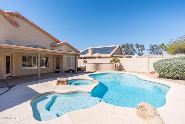 view of pool with a fenced backyard, a pool with connected hot tub, and a patio