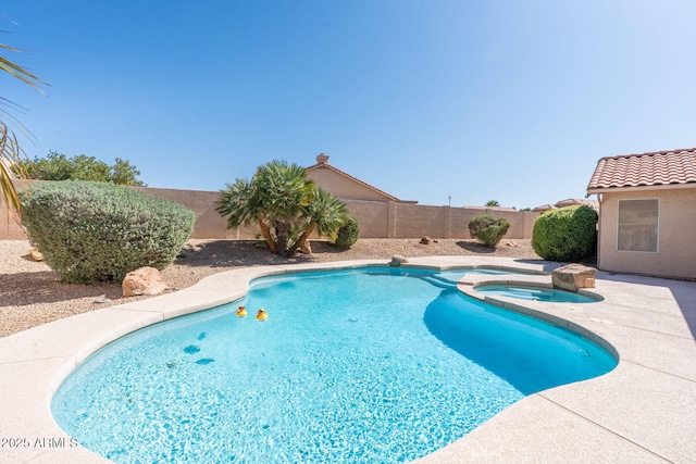 view of swimming pool featuring a fenced backyard and a pool with connected hot tub