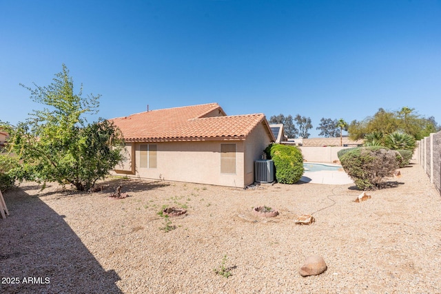 view of home's exterior featuring stucco siding, a fenced backyard, cooling unit, and a tiled roof