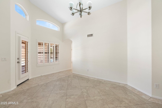 unfurnished room featuring baseboards, visible vents, high vaulted ceiling, arched walkways, and a notable chandelier