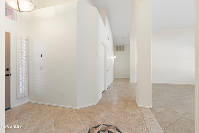 entryway with light tile patterned floors, visible vents, baseboards, and a wealth of natural light