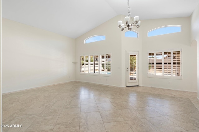 interior space with baseboards, a notable chandelier, and high vaulted ceiling