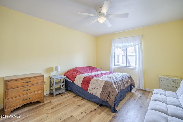 bedroom with light wood finished floors, baseboards, and a ceiling fan