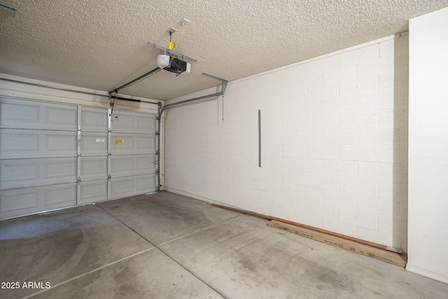 garage with a garage door opener and concrete block wall