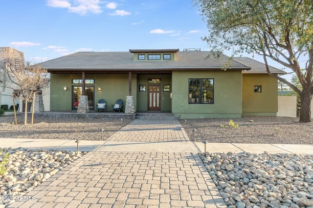 prairie-style home featuring a tiled roof and stucco siding