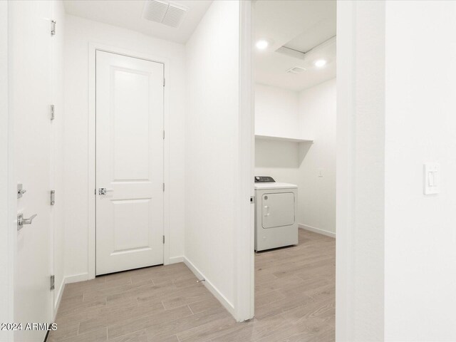 hallway featuring washer / clothes dryer and light hardwood / wood-style flooring