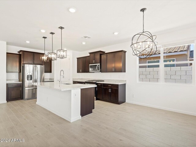 kitchen with pendant lighting, a kitchen island with sink, light hardwood / wood-style flooring, and stainless steel appliances