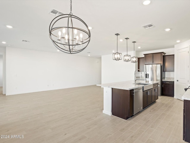 kitchen with pendant lighting, light wood-type flooring, and appliances with stainless steel finishes