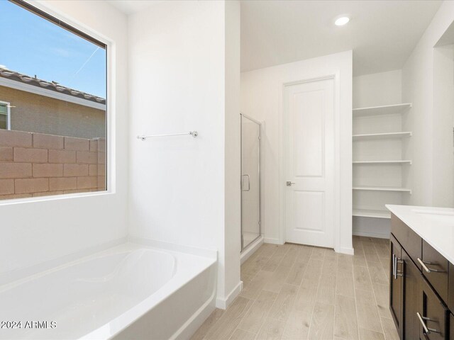 bathroom with separate shower and tub, hardwood / wood-style floors, and vanity