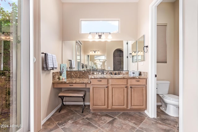 bathroom featuring tile patterned floors, toilet, plenty of natural light, and vanity