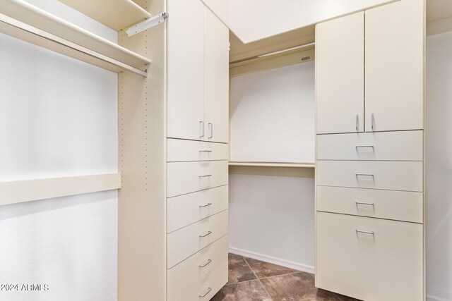 spacious closet featuring dark tile patterned floors