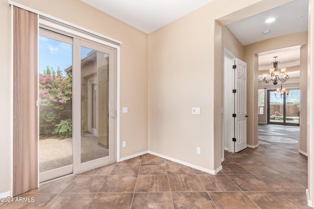 spare room with an inviting chandelier and tile patterned floors