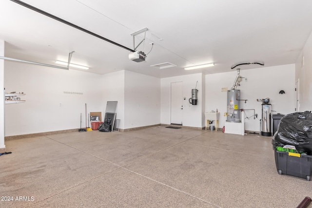 garage with a garage door opener, water heater, and sink