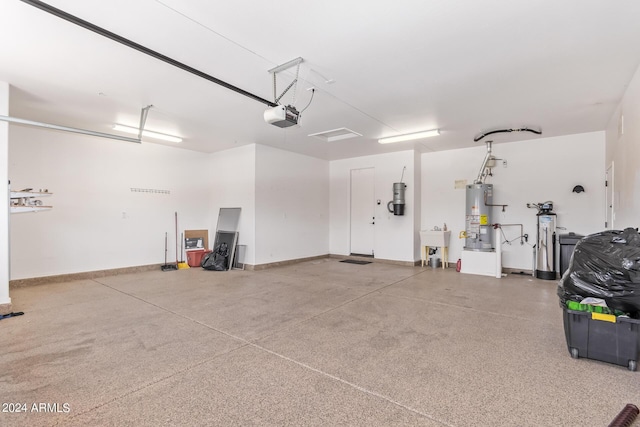 garage featuring sink, a garage door opener, and gas water heater