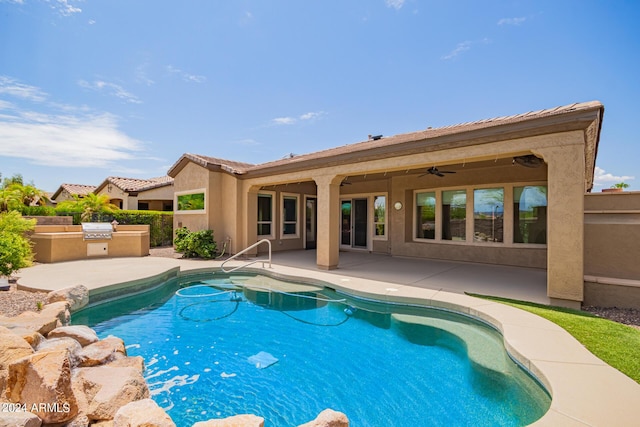 view of swimming pool featuring ceiling fan, an outdoor kitchen, and a patio