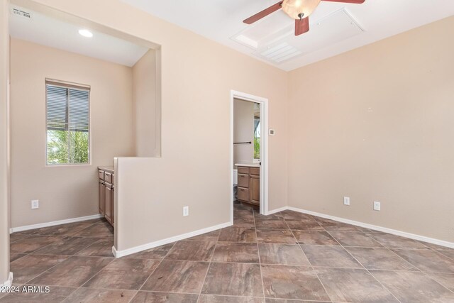 unfurnished bedroom featuring tile patterned flooring, ceiling fan, and connected bathroom