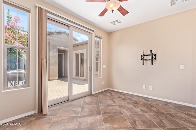 spare room with ceiling fan and tile patterned floors