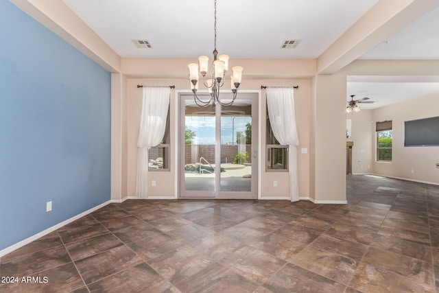 spare room featuring ceiling fan with notable chandelier