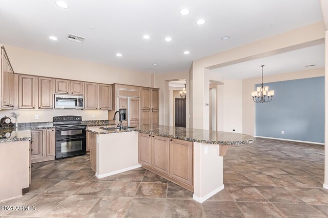 kitchen featuring sink, a center island with sink, black / electric stove, light tile patterned floors, and dark stone counters